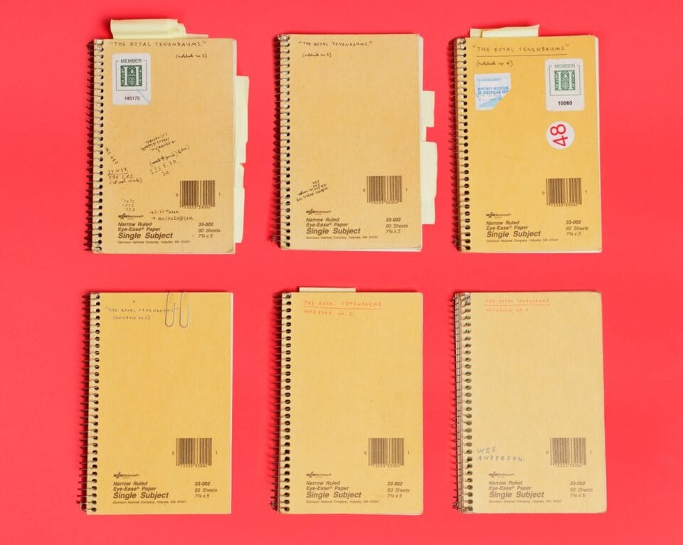 six yellow notebooks in a group against a bright red background