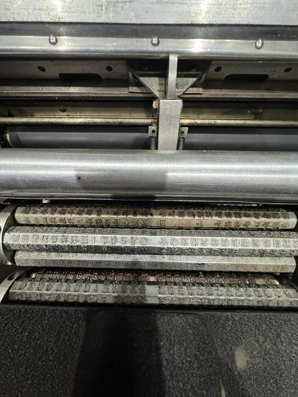 the inner workings of a rare Chinese character typewriter, showing metal bars with numerous keys