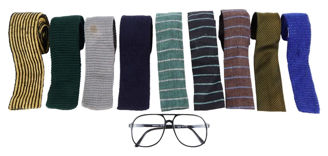 a series of vintage neckties and black-framed glasses