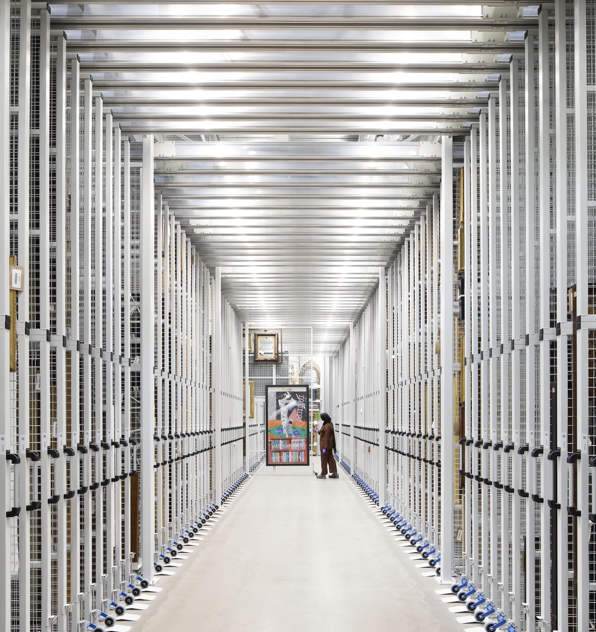 the interior of a contemporary museum collection storehouse with numerous racks of paintings in storage
